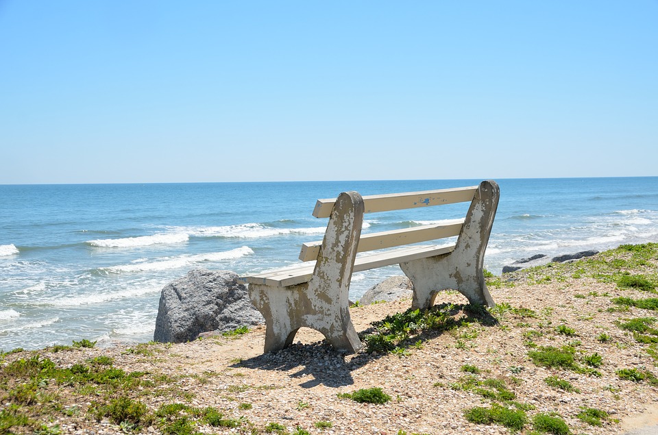 Empty bench on the sand overlooking the beach. 